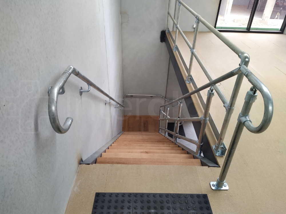 Interclamp DDA Assist 5000 series installed on a staircase leading to a mezzanine floor